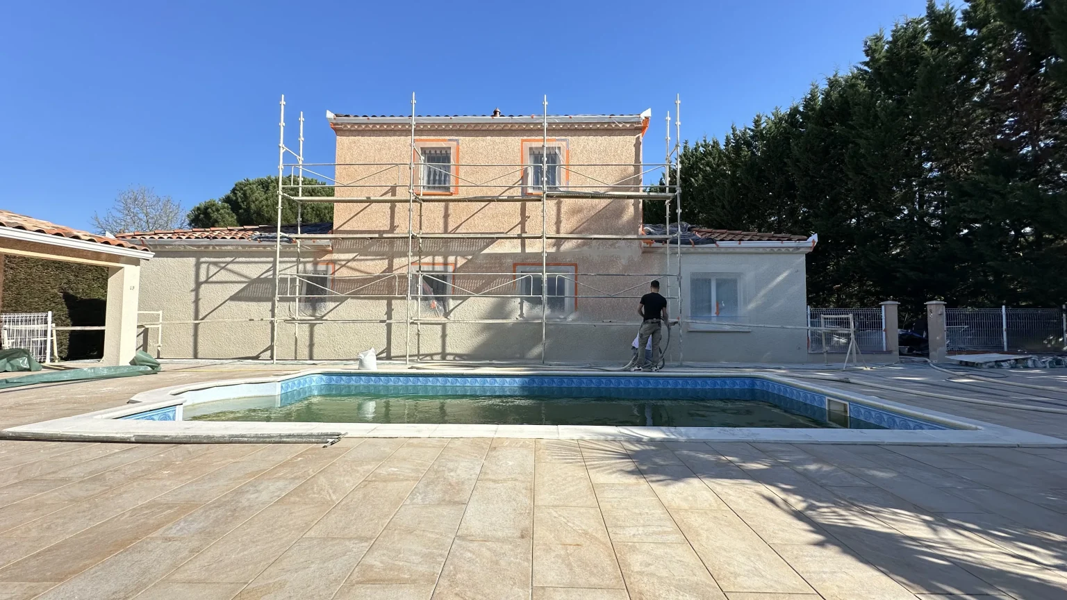Artisan peintre façadier albi appliquant une peinture extérieure blanche au pistolet airless lors du ravalement d'une façade de maison à Albi (Tarn 81).